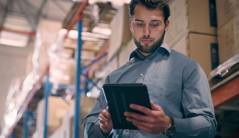 Warehouse worker scanning inventory with order management software Warehouse worker scanning inventory on iPad device